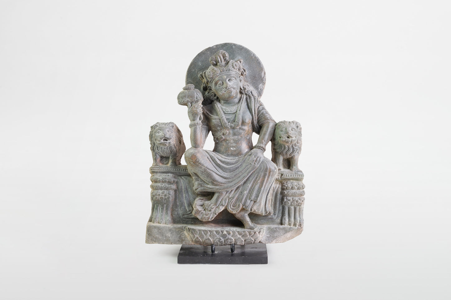 Gandharanische Figur des Panchika auf einem Thron sitzend, flankiert von zwei Löwen – Indien, 2.–3. Jahrhundert